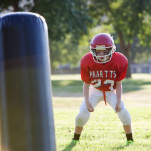 Young football player practicing blocking